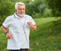 Positive running old man in green city park. Royalty Free Stock Photo