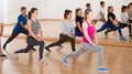 Teenage boys and girls with trainer stretching in dance hall Royalty Free Stock Photo