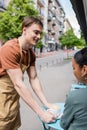 Positive salesman putting cappuccino near african