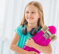 Positive school girl with penny board Royalty Free Stock Photo