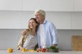 Positive senior dad and adult daughter cooking in home kitchen Royalty Free Stock Photo