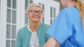 Positive senior lady nods head listening to caregiver recommendations in light office