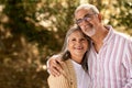 Positive senior man hug woman in casual, enjoy walk together, romantic date in park outdoor Royalty Free Stock Photo