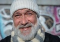 Positive senior man in white knitted hat and scarf. Happy smiled man with white grey bear