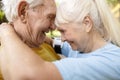 Positive senior woman and man hugs spending time together in spring park