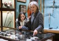 Senior woman and preteen girl observing antique pistols in museum