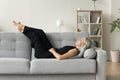 Positive serene mature woman lying on couch with closed eyes