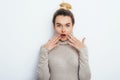 Positive shocked female with attractive look and lips wearing in sweater posing against white wall. Happy woman with hair bun Royalty Free Stock Photo