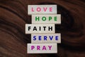 Positive single word on wooden blocks - Love. Hope. Faith. Serve. Pray. Colorful inspirational text sign concept on wood blocks.