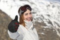 Positive skier woman gesturing thumb up in winter