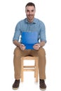 Positive smart casual man holding clipboard and smiling