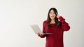 A smart Asian female college student is pointing her finger at her head while holding her laptop Royalty Free Stock Photo