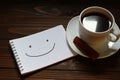 Positive smiley inscription and word in a notebook near a cup of coffee