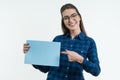 Positive smiling girl student holding a cleaned sheet of blue paper, pointing a finger at the paper. Royalty Free Stock Photo