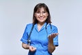 Positive smiling nurse in blue uniform looking at camera on light studio background Royalty Free Stock Photo