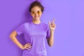Positive smiling teen girl pointing fingers at side, index Royalty Free Stock Photo