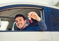 Positive smiling young man driver showing car keys out window Royalty Free Stock Photo