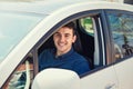 Positive smiling young man driver sitting behind the steering wheel driving his brand new car Royalty Free Stock Photo