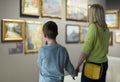 Mother and son looking at paintings in halls of museum Royalty Free Stock Photo