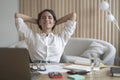 Freelancer lady sitting in front of laptop in relaxed position, eyes closed and hands behind head Royalty Free Stock Photo