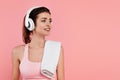 Positive sportswoman in headphones with towel