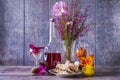 Two pieces of cake in plate, bottle of wine, wild flowers in vase and wine glasses stand on wooden table. Positive mood. Royalty Free Stock Photo