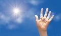 Positive symbol drawing by sunscreen sun cream, suntan lotion on open hand on blue sky background. Royalty Free Stock Photo