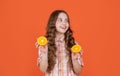 positive teen child hold citric fruit on orange background