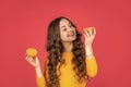 positive teen child hold orange fruit on pink background