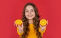 positive teen child hold orange fruit on purple background