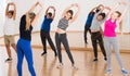 Teenage boys and girls with trainer stretching in dance hall Royalty Free Stock Photo