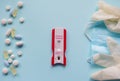 Positive test for Covid-19. On the right - medical mask and gloves, on the left - multi-colored tablets. Blue background. The