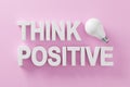 Positive thinking and optimism in business or life concept. The word think positive with an idea light bulb on pink background Royalty Free Stock Photo