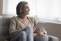 Positive thoughtful beautiful grey haired woman enjoying Internet technology