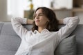 Positive thoughtful lazy pretty young woman sitting on couch