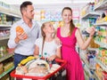 Positive three customers smiling and standing with purchases