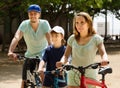 Positive tourists with kid riding bicycles in park Royalty Free Stock Photo