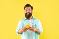 positive unshaven man in shirt with coffee on yellow backdrop, barista