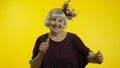 Positive happy senior old woman enjoying party music, moving in energetic dance, celebrating success Royalty Free Stock Photo