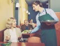 Positive waiter bringing order to mature female