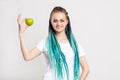 Positive woman bright blue hair braids green apple