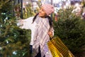 Positive woman choosing New Year`s tree in christmas fair Royalty Free Stock Photo