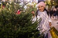 Positive woman choosing New Year's tree in christmas fair Royalty Free Stock Photo