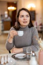 Positive woman enjoying cup of delicious espresso in cafe Royalty Free Stock Photo