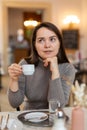 Positive woman enjoying cup of delicious espresso in cafe Royalty Free Stock Photo