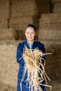 Cheerful woman farmer holding bunch of hay Royalty Free Stock Photo