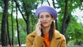 positive woman in fashionable autumn clothes talking on smartphone in park.