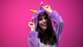 Positive woman fooling around wearing funny unicorn pajamas, having fun, party