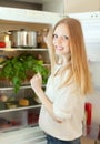 Positive woman looking for something in refrigerator Royalty Free Stock Photo