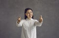 Positive woman makes finger pistols pointing straight at the camera saying I choose you. Royalty Free Stock Photo